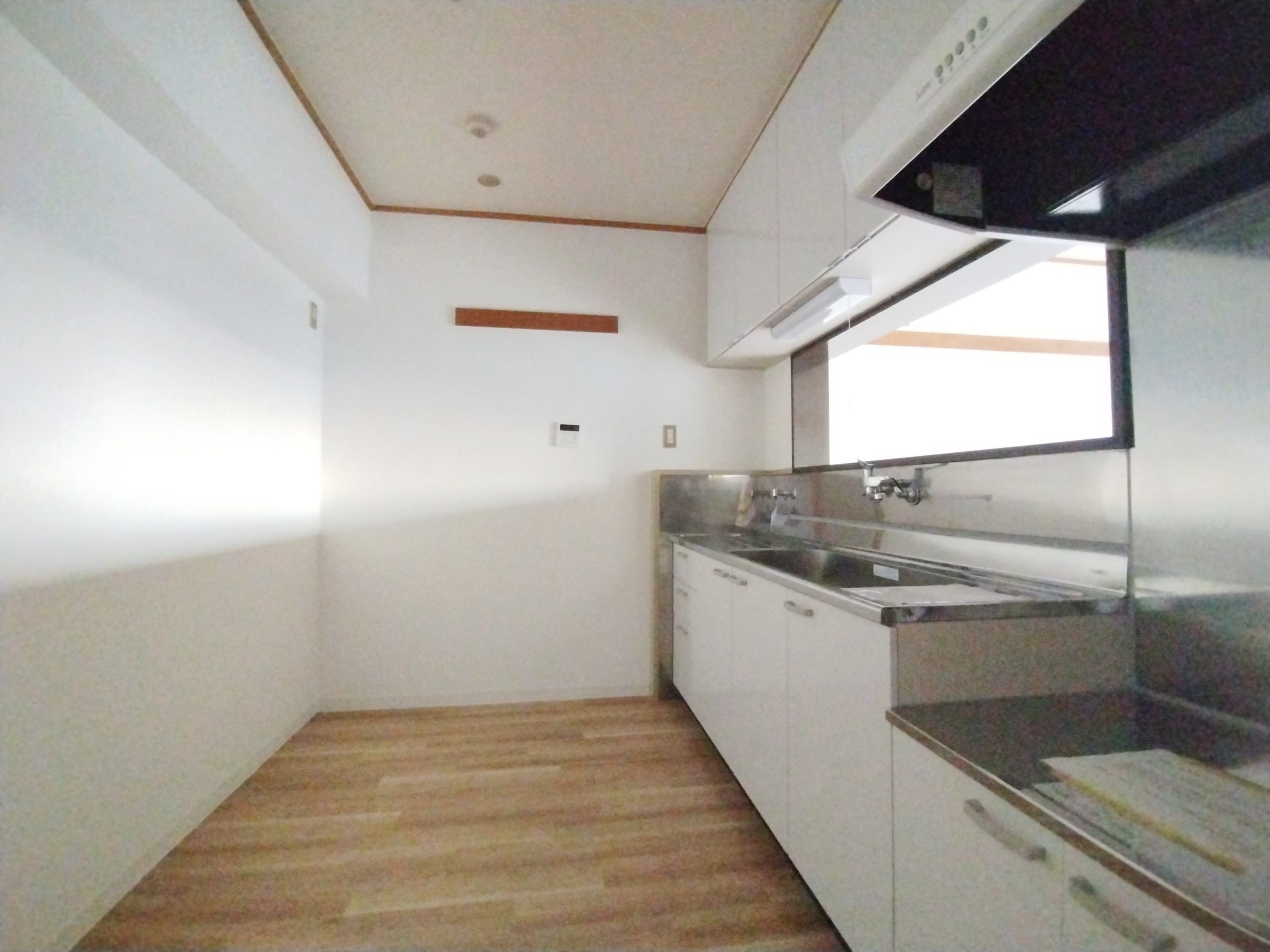 シンプルな白いキッチンと奥行きのある台所